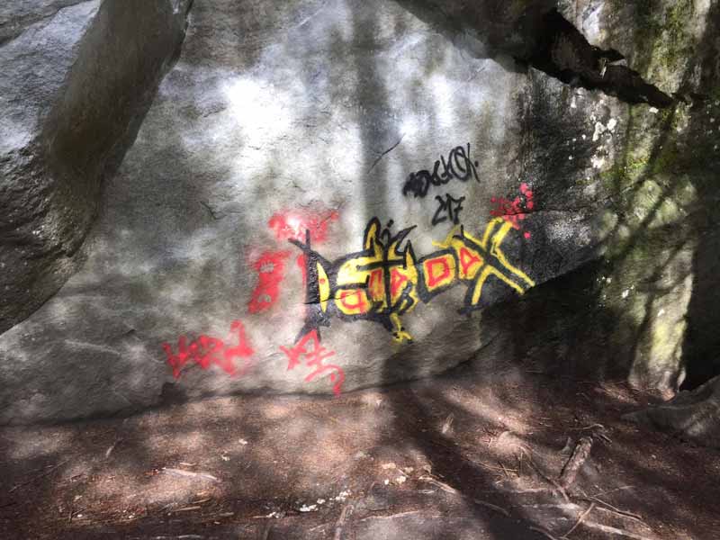 Graffiti an Boulderblock im Magic Wood - Schmiererei