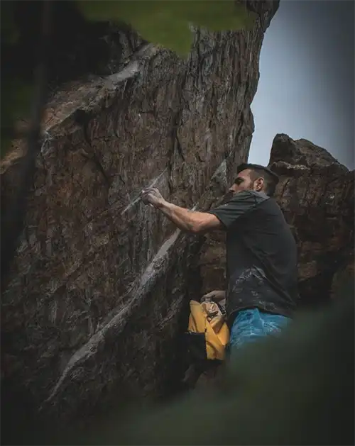 Elias Iagnemma putzt die kleinen Leisten seiner Erstbegehung Afrodite (8B+). Bild: @steppph_dove